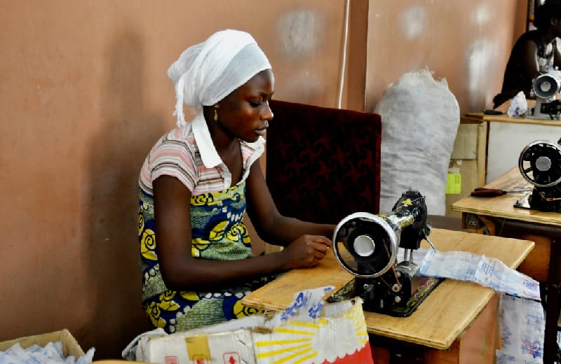 Woman using sewing machine working workshop